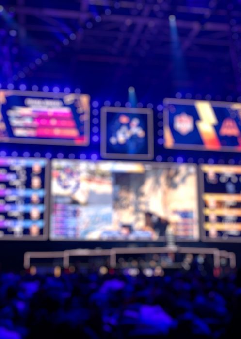 Blurred background of an esports event - Big illuminated main stage of a computer games tournament